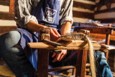 Ruční vochlování lnu, protahování vláken přes hrubou vochli