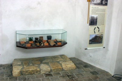 Nad rekonstruovanou oltářní mensou se nachází prosklená vitrína 
se skutečnými archeologickými nálezy