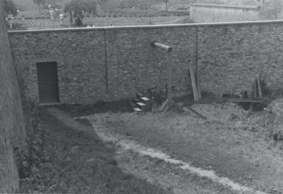 Časť popraviska so šibenicou, za múrom bývalej zeleninárskej
záhrady SS. Postavy v bielom sú väčšinou ženy, najskôr zdravotníčky
z Českej pomocnej akcie, po oslobodení Terezína 1945
