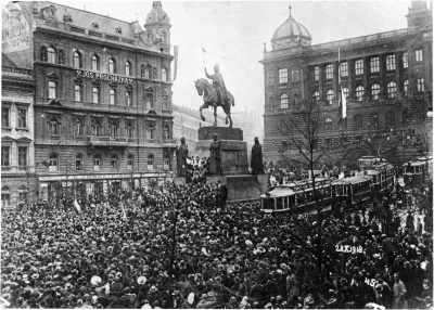 Zástup lidí u sochy sv. Václava se vztyčenou československou vlajkou, 28. října 1918
